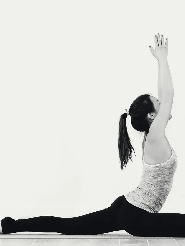 Inès R. en posture de yoga, bras tendus vers le ciel.